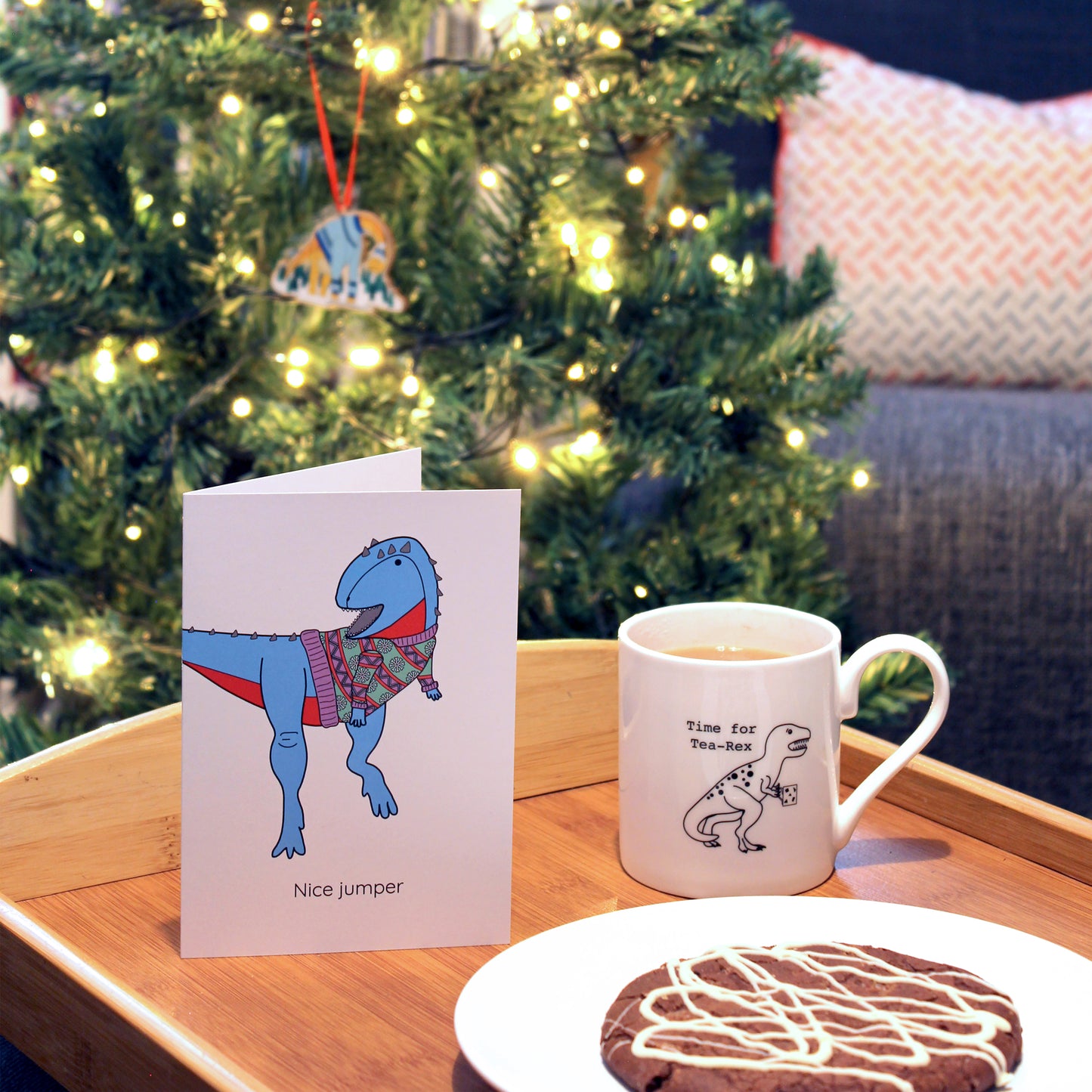 nice jumper greeting card on a tray with a cookie and a cup of tea, there is a Christmas tree in the background