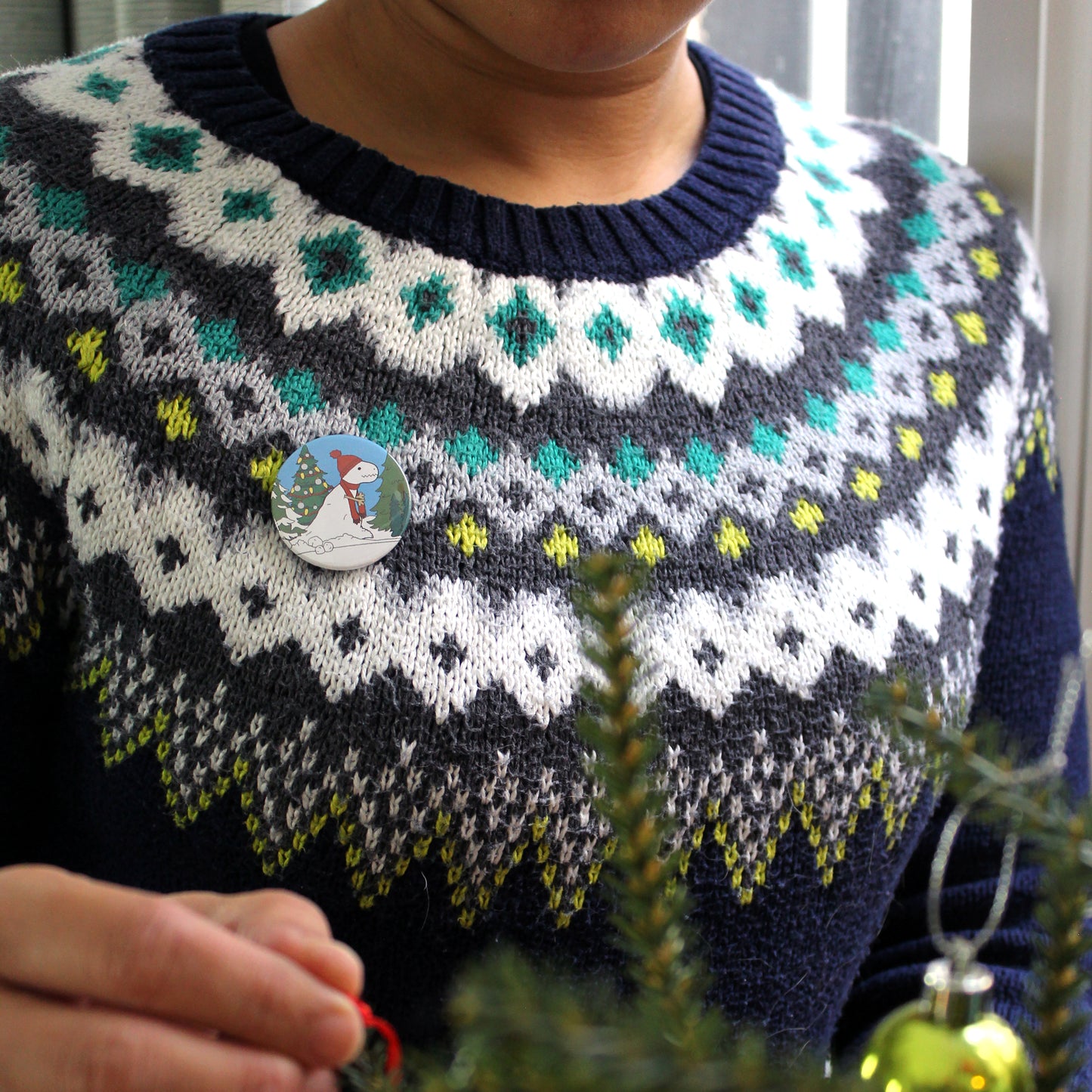 mini snow-rex badge on a festive fairisle jumper