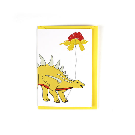greeting card featuring a stegosaurus dinosaur holding a balloon dinosaur on a string