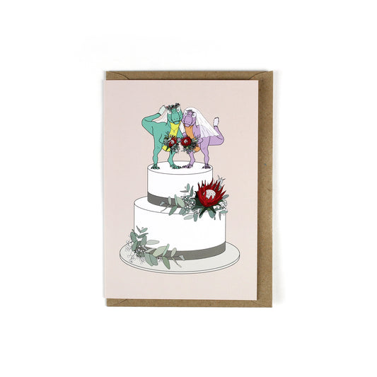 greeting card featuring two bride dinosaurs on a white wedding cake.