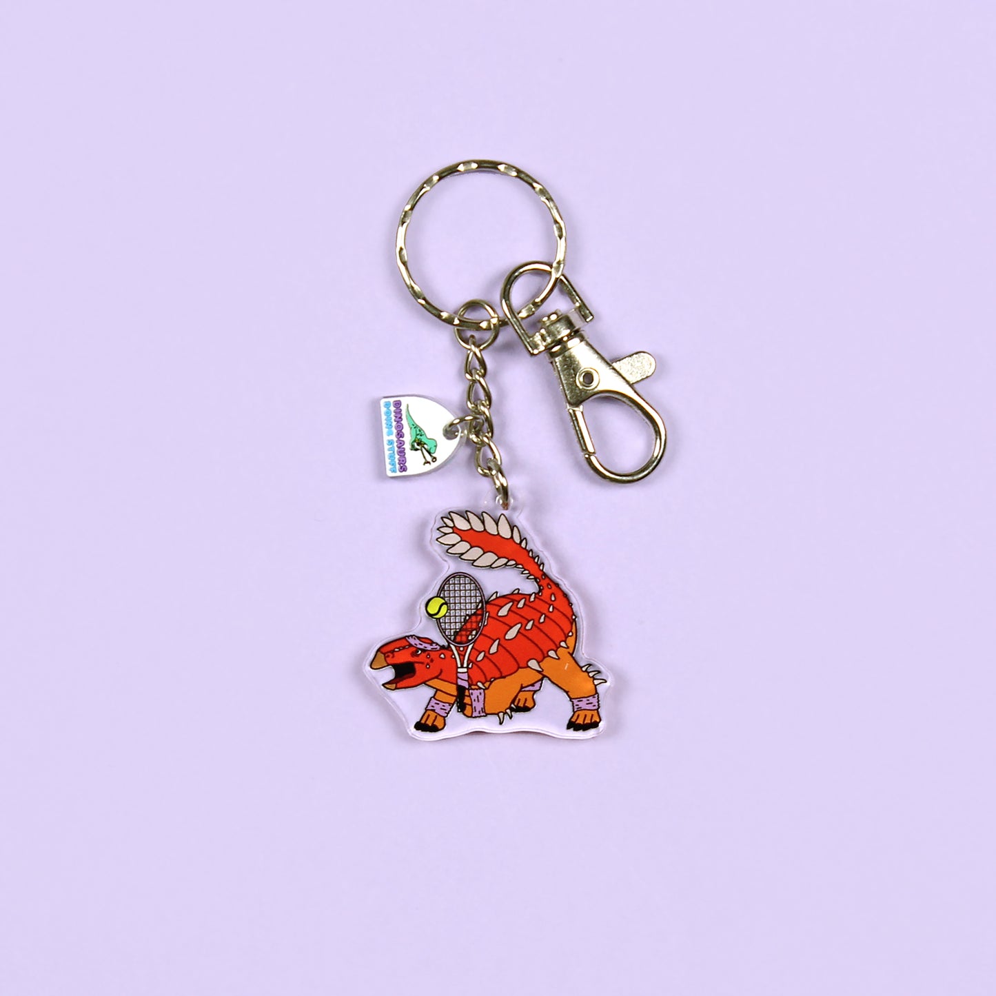 Tennis Dinosaur Keyring on a purple background