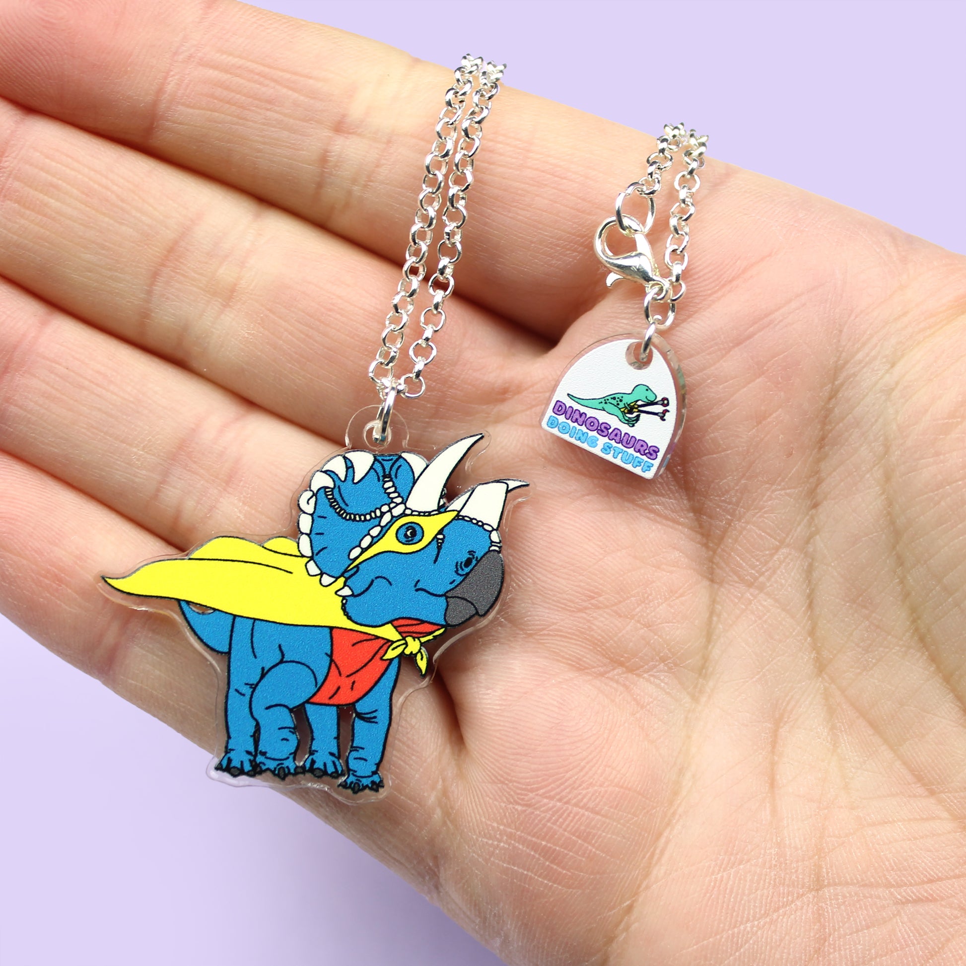 Superhero Dinosaur Necklace on a hand