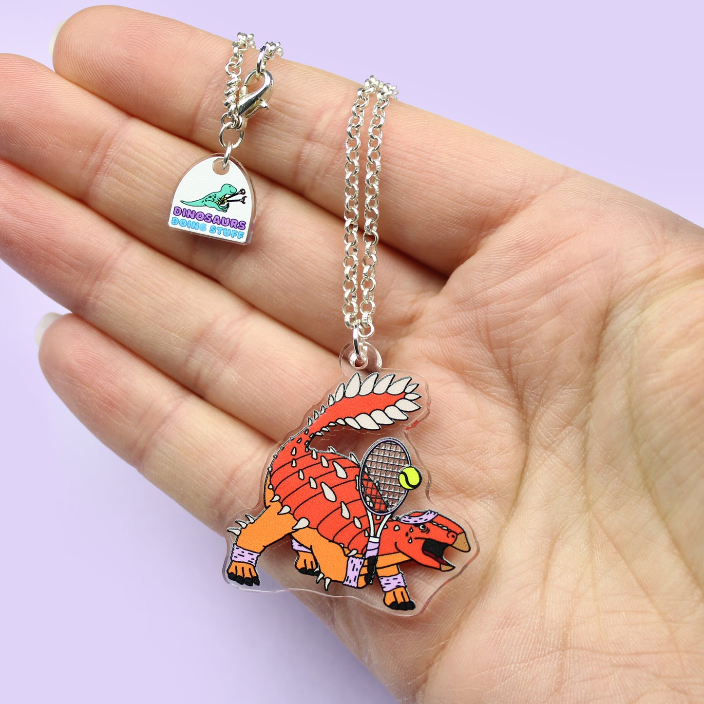 Tennis Dinosaur Necklace on a hand