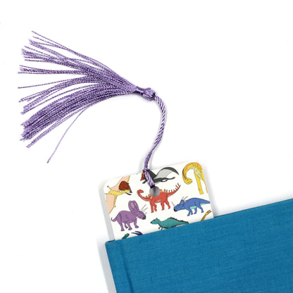 scatter dinosaur bookmark with purple tassel coming out of a blue book
