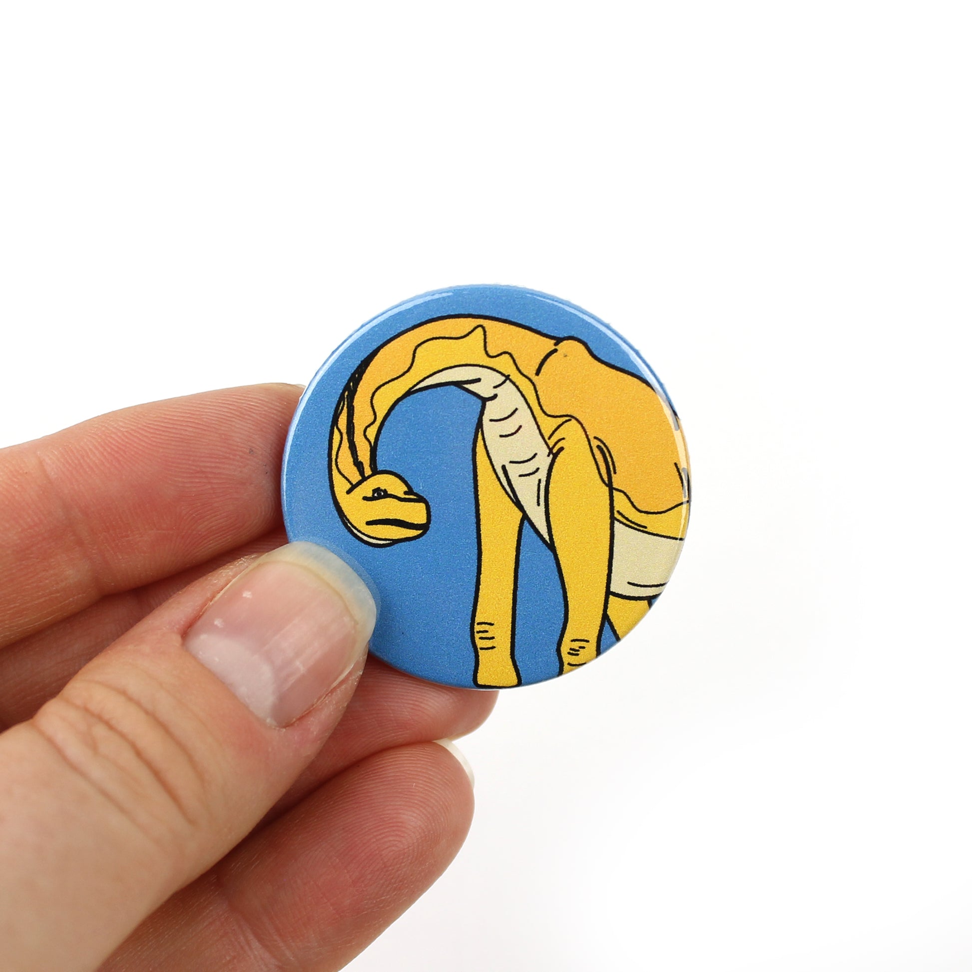 hand holding a giraffatitan mini badge