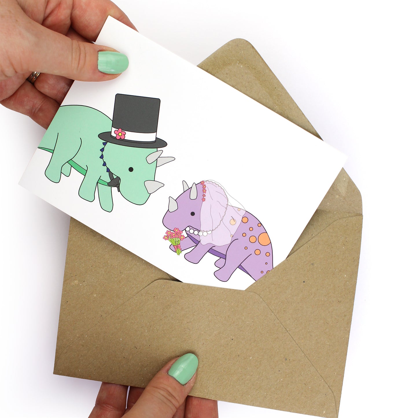 hands holding an envelope while removing the dinosaur wedding card from the envelope