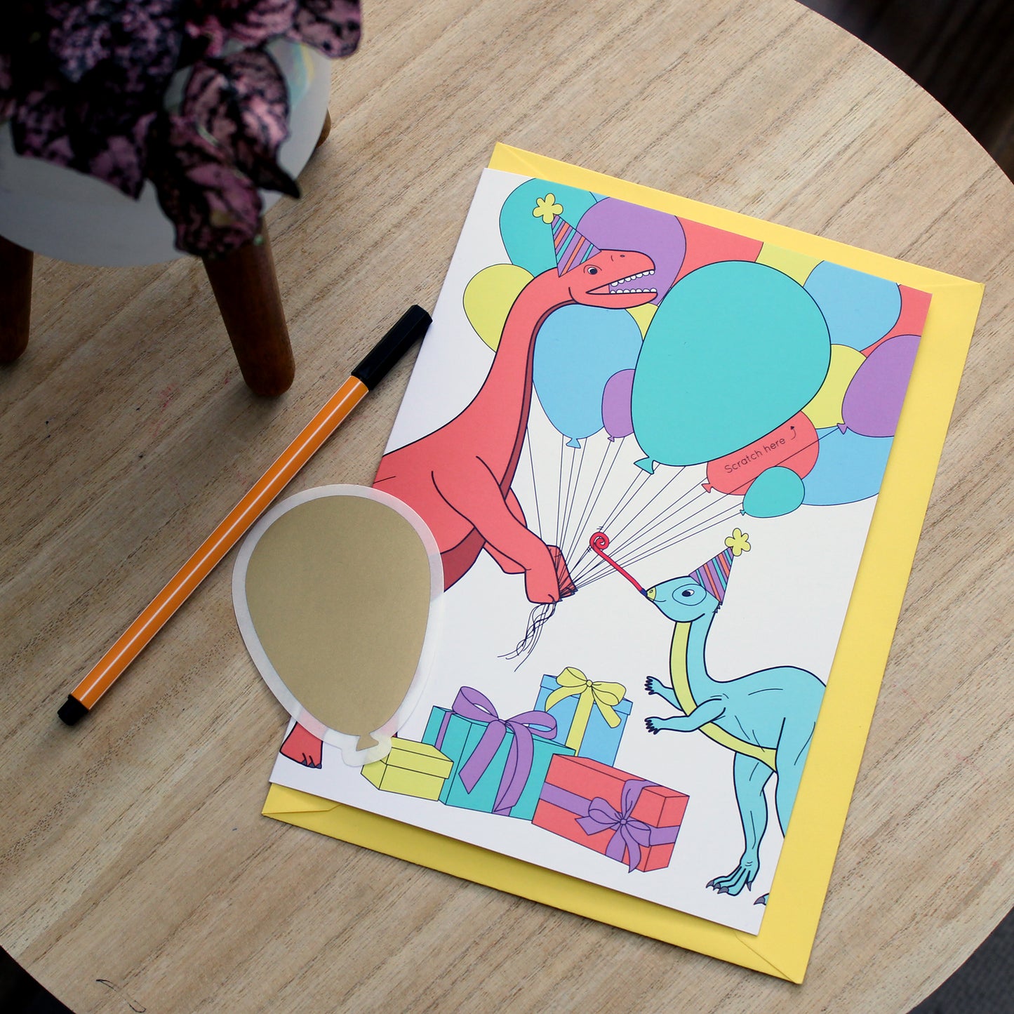 Dinosaur balloon scratch card on table