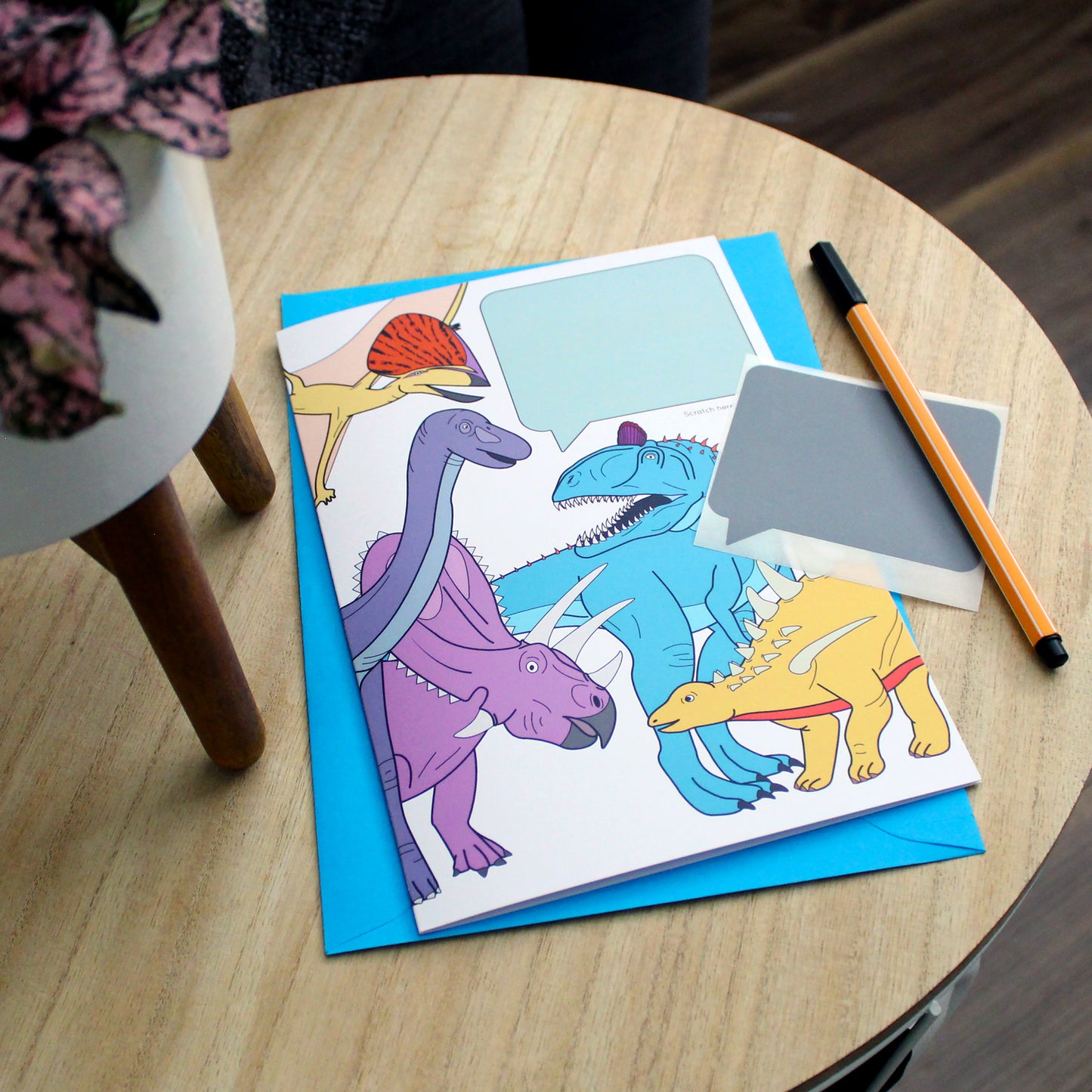 dinosaur speech bubble scratch card on table
