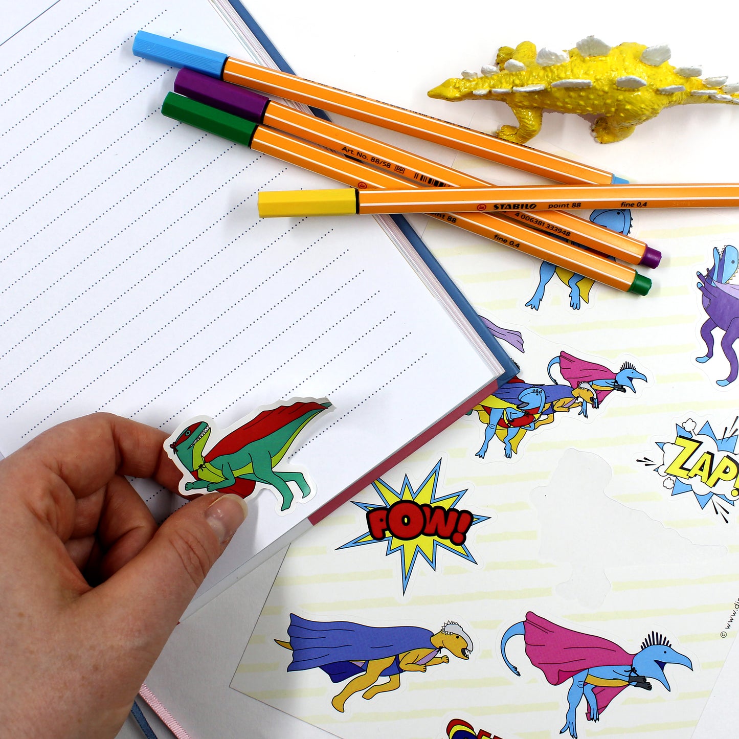 dinosaur superhero sticker on notebook