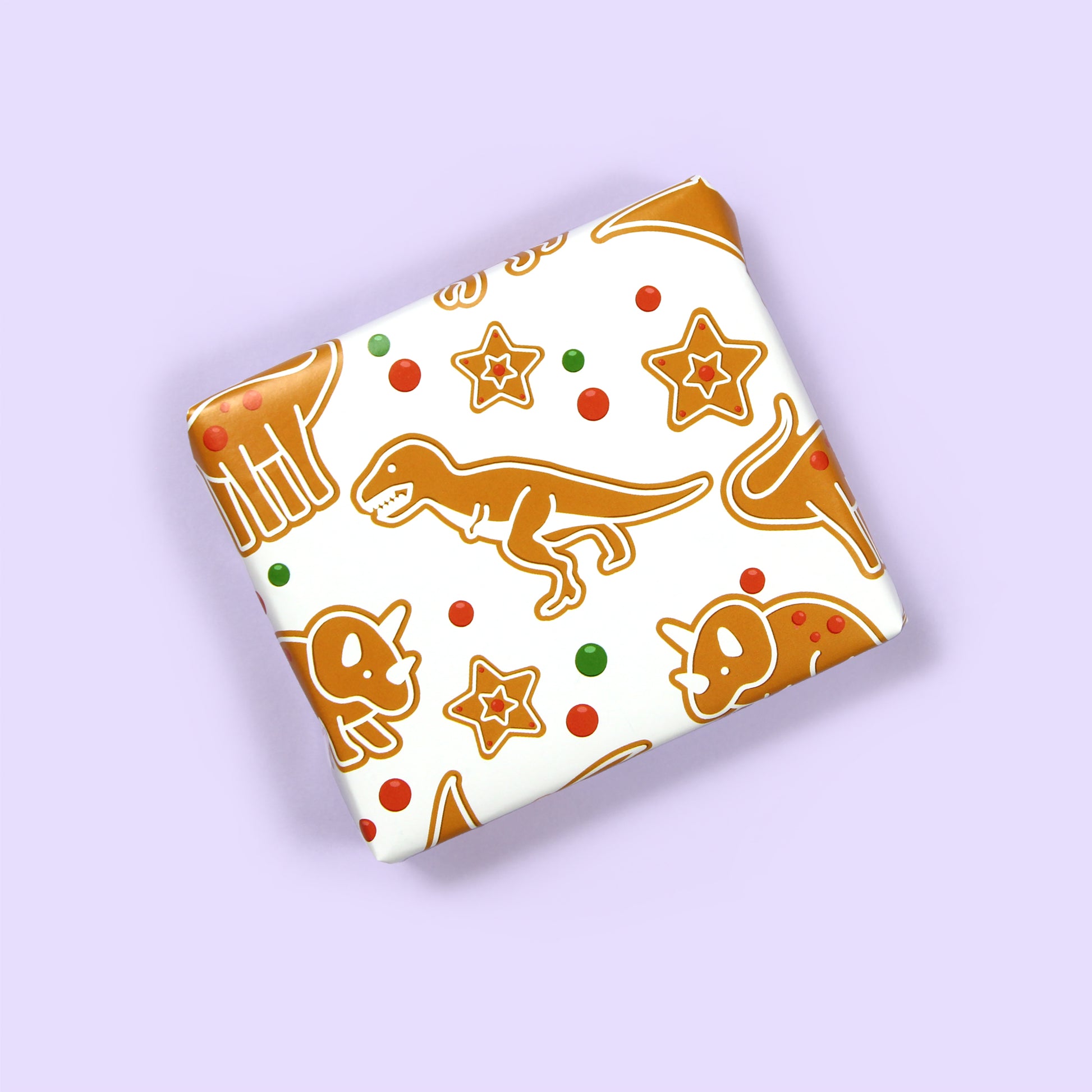 a small box wrapped in Christmas gingerbread Dinosaur Wrapping Paper