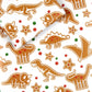 a sheet of gingerbread dinosaur wrapping paper with a box on top that is also wrapped in the same paper