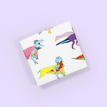a small box wrapped in superhero Dinosaur Wrapping Paper