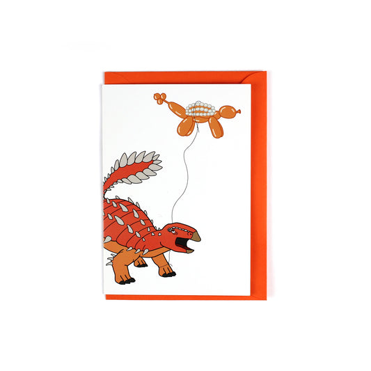 greeting card featuring a ankylosauria dinosaur holding a balloon dinosaur on a string