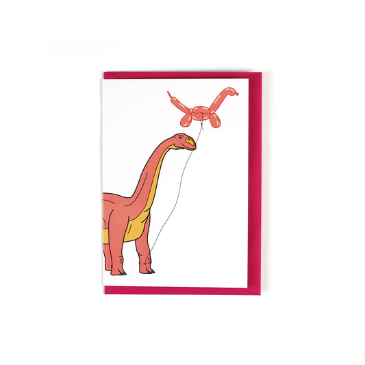 greeting card featuring a long neck dinosaur holding a balloon dinosaur on a string 