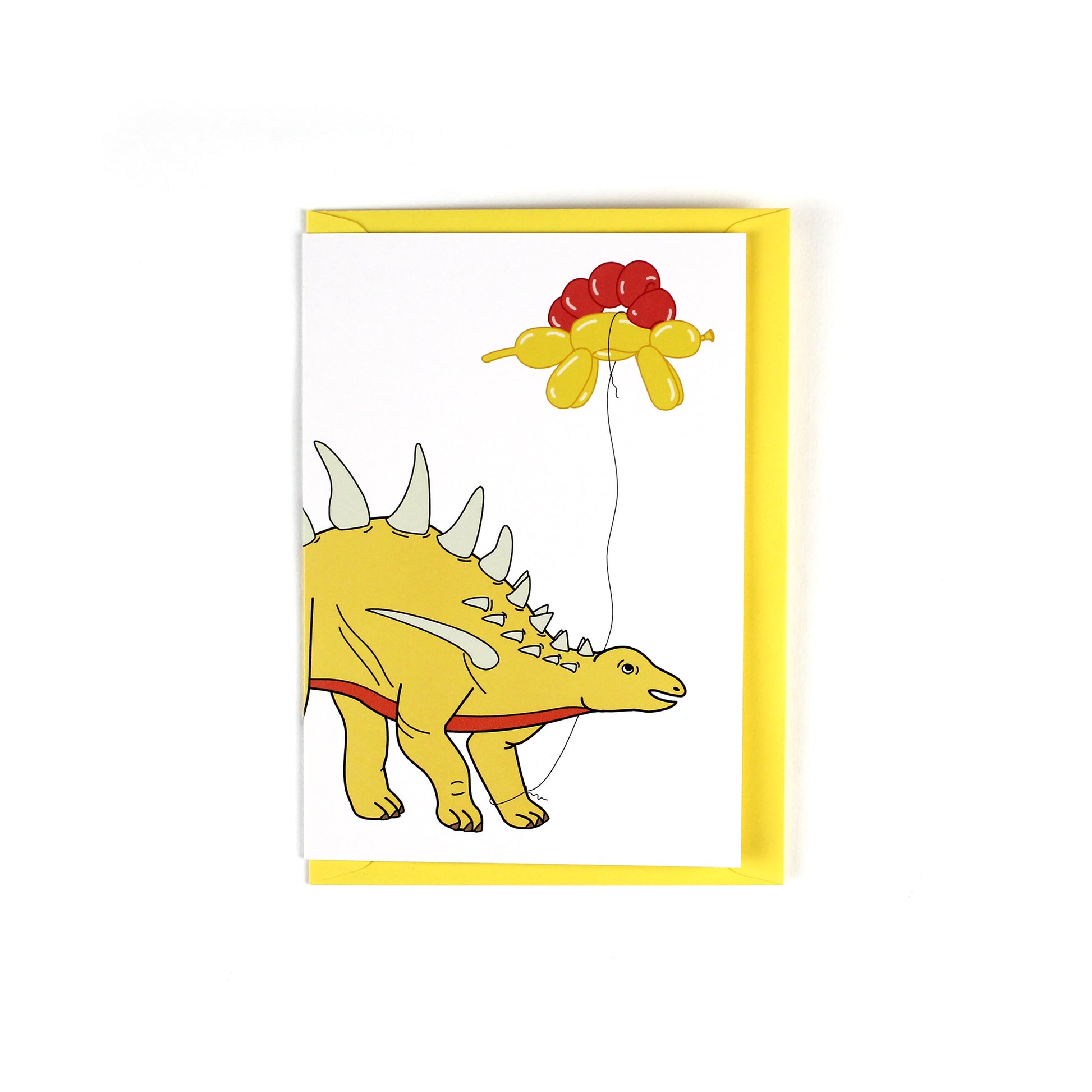 greeting card featuring a stegosaurus dinosaur holding a balloon dinosaur on a string