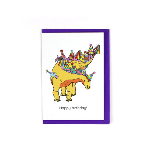 greeting card featuring a yellow and orange spiked dinosaur with colourful party hats on its spikes