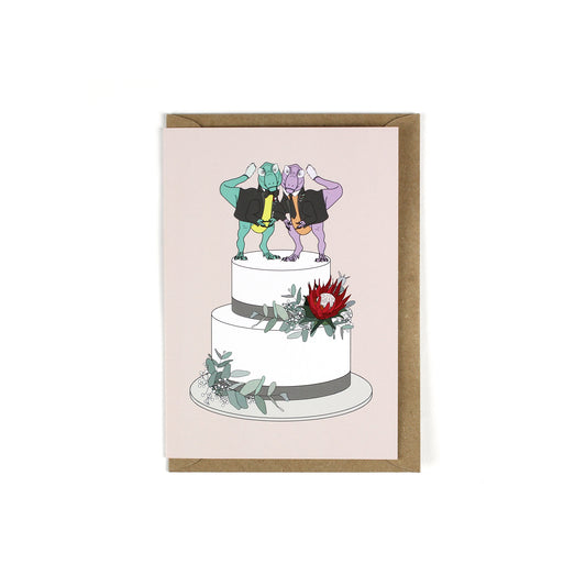 greeting card featuring 2 male dinosaurs on a wedding cake