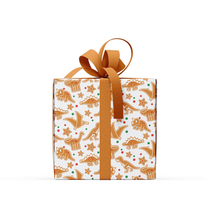 Present wrapped in gingerbread dinosaur wrapping paper with a brown ribbon