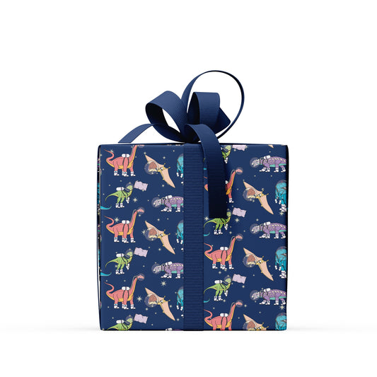 a box covered in space dinosaur wrapping paper with a navy ribbon