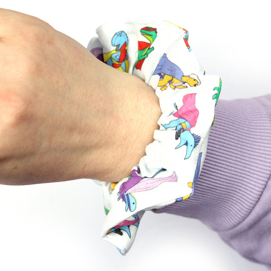 superhero dinosaur scrunchies on an wrist