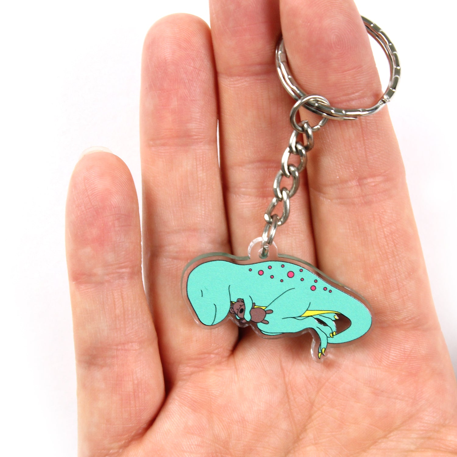 Dino-snore t-rex dinosaur keyring on a hand with the split ring over a finger