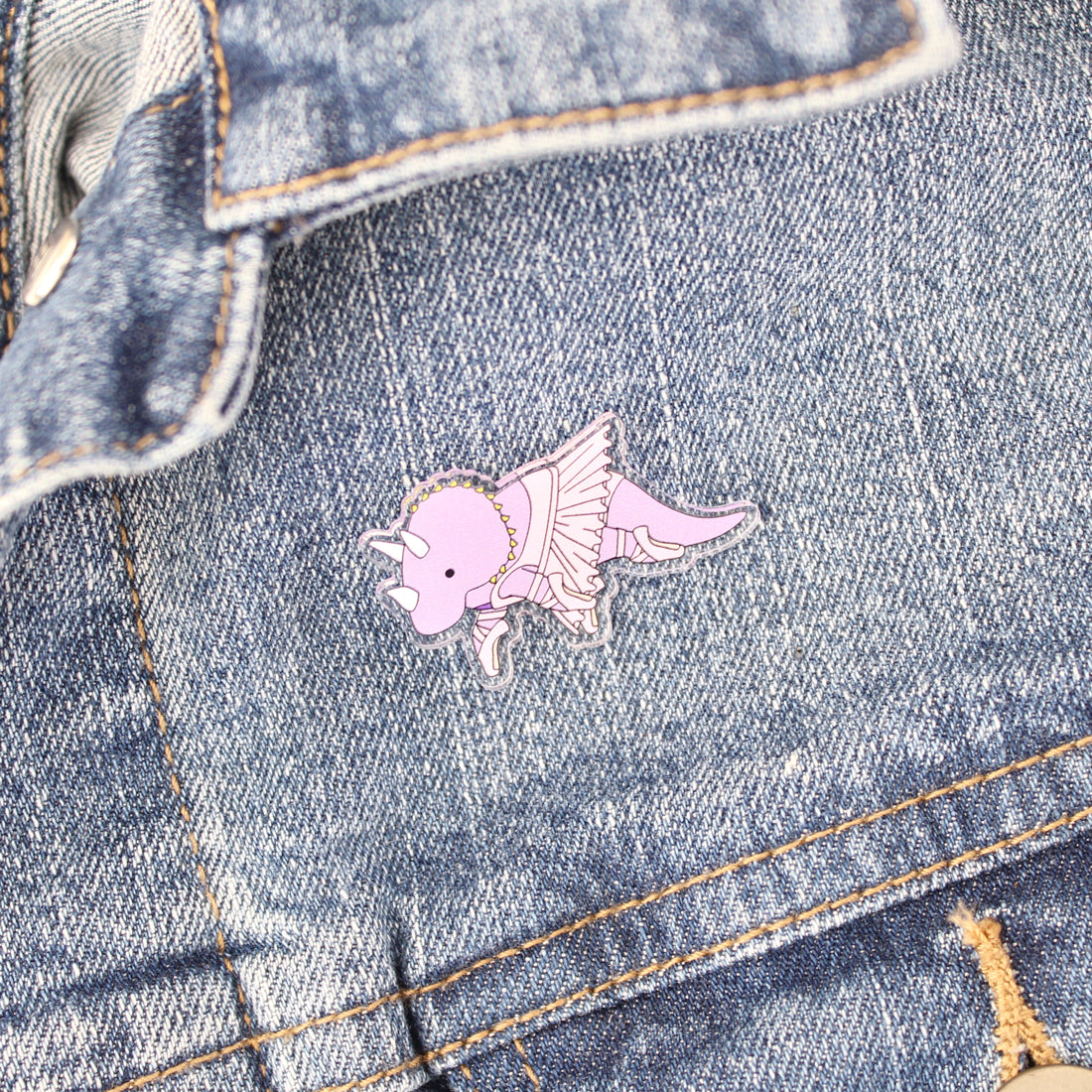 ballerina triceratops acrylic pin on a denim jacket