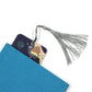 space dinosaur bookmark with a grey tassel coming out of a blue book