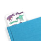 dinosaur words bookmark coming out of a blue book