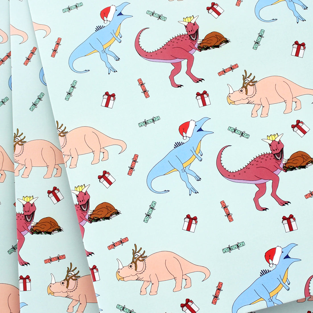 3 sheets of Dinner Dinosaur Christmas Wrapping Paper fanned out