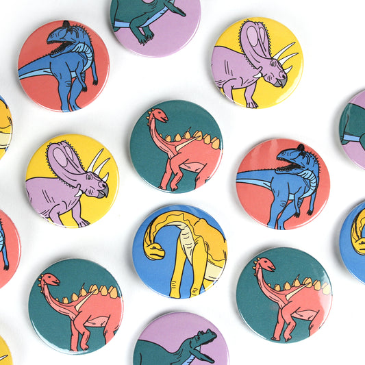 mini dinosaur badges spaced out on a white background