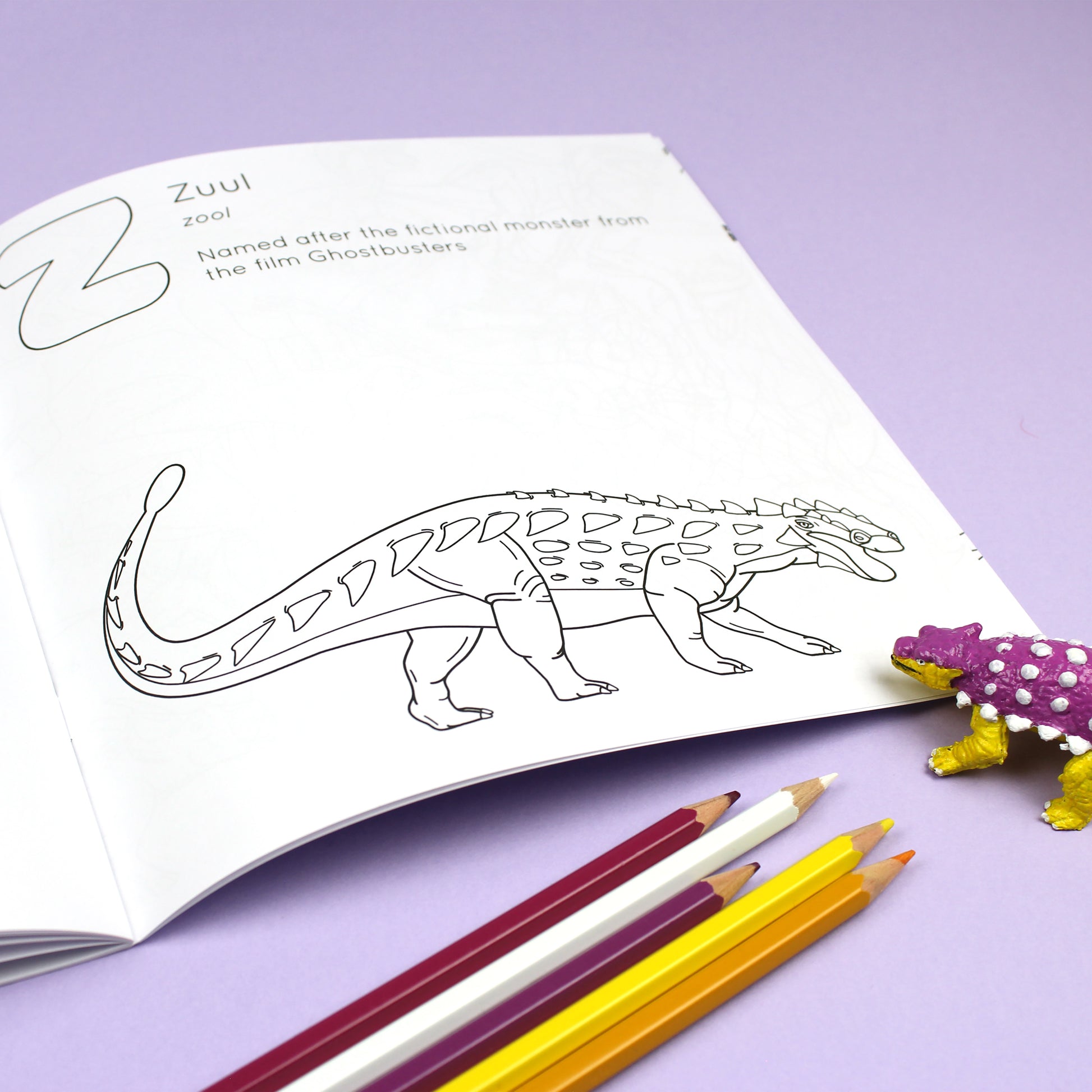 Inside page of ABC Dinosaur colouring book. The page features black line illustration of a Zuul dinosaur with its name, pronunciation and meaning above it.