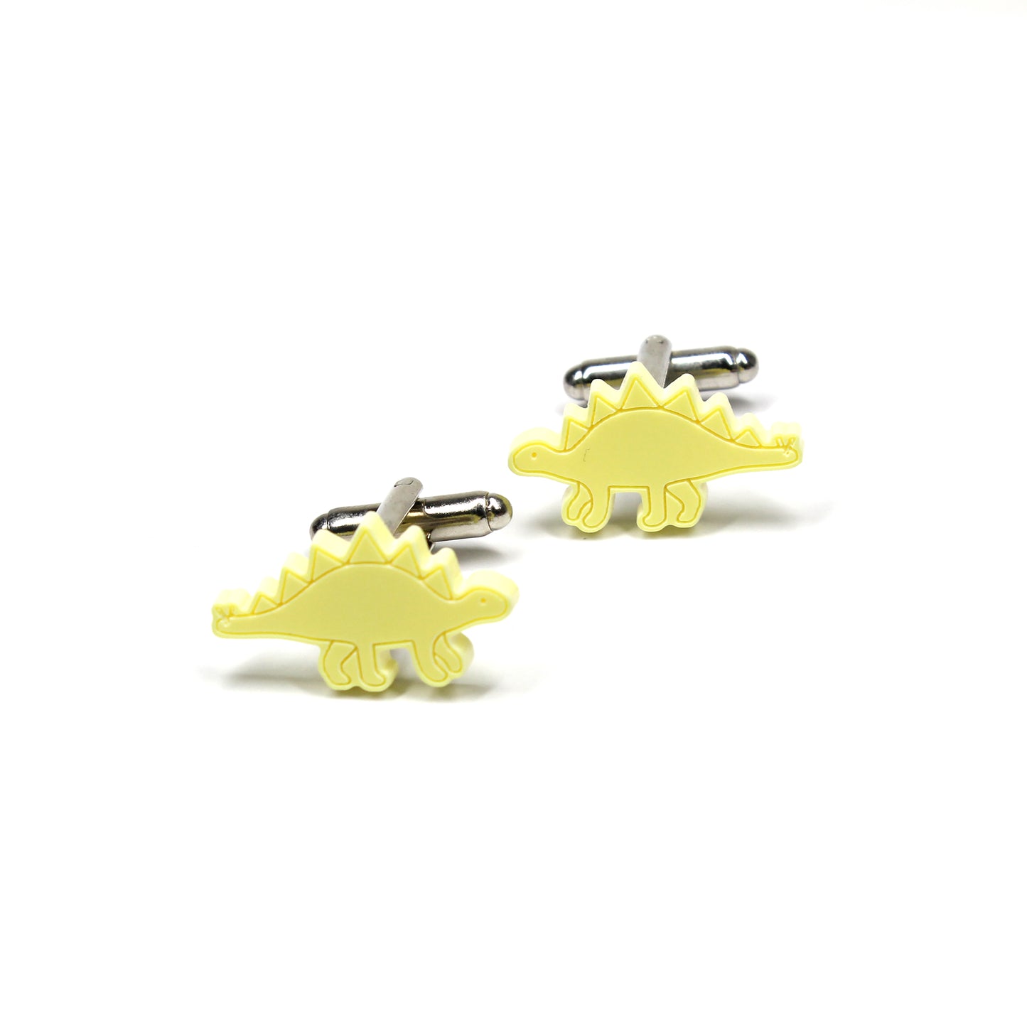 a pair of yellow stegosaurus cufflinks on a white background