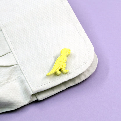 yellow tyrannosaurus-rex dinosaur cufflinks on a shirt cuff