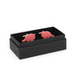 a pair of red triceratops cufflink in a black box