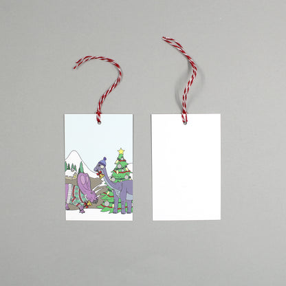 flat lay showing the front and back of the winter dinosaur gift tag on a grey background