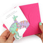 hands holding an envelope while removing the  pink hatchling card from the envelope