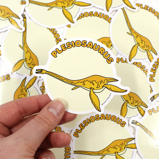 plesiosaur sticker held by a hand with plesiosaur stickers in the background