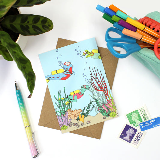 under the sea postcard and envelope on a white background with stamps, pens and a plant