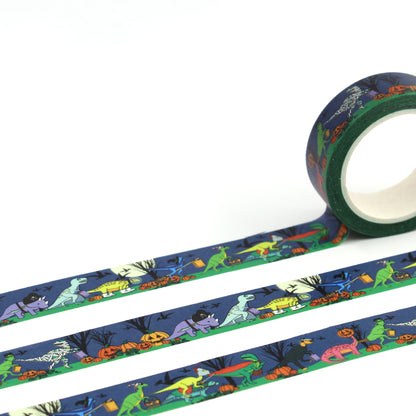 A roll of Halloween dinosaur washi tape rolled out showing the full design