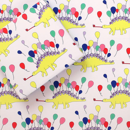 a sheet of Dinosaur Party Animal Wrapping Paper with a small box on it wrapped in the same design