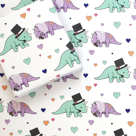 a sheet of triceratops wedding dinosaur wrapping paper with a box on top that is also wrapped in the same paper